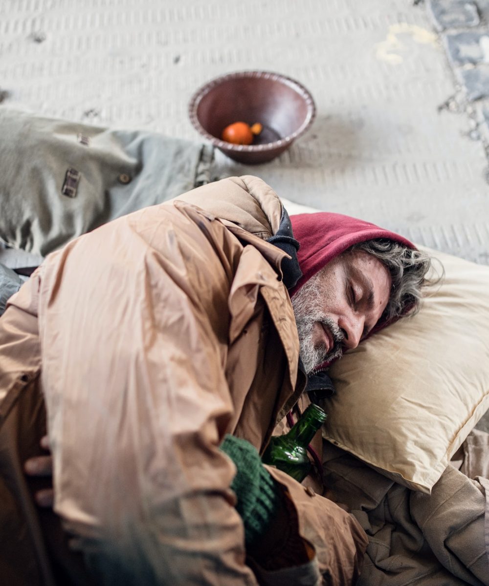 homeless-beggar-man-lying-on-the-ground-outdoors-in-city-sleeping-.jpg